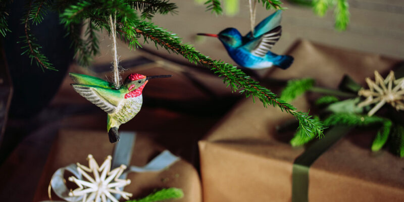 vogelhangers in de kerstboom met cadeaus eronder